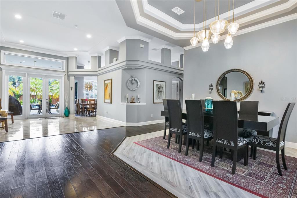 A spacious foyer with dark hardwood floors leads to a dining area and glass patio doors — 1623 CONWAY ISLE CIRCLE, BELLE ISLE, FL