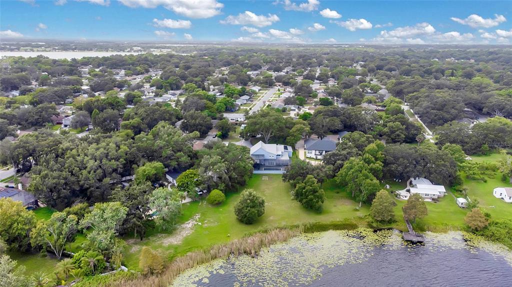 An aerial view of a house with a large backyard leading to a lake — 1317 SPRING LAKE TERRACE, OCOEE, FL