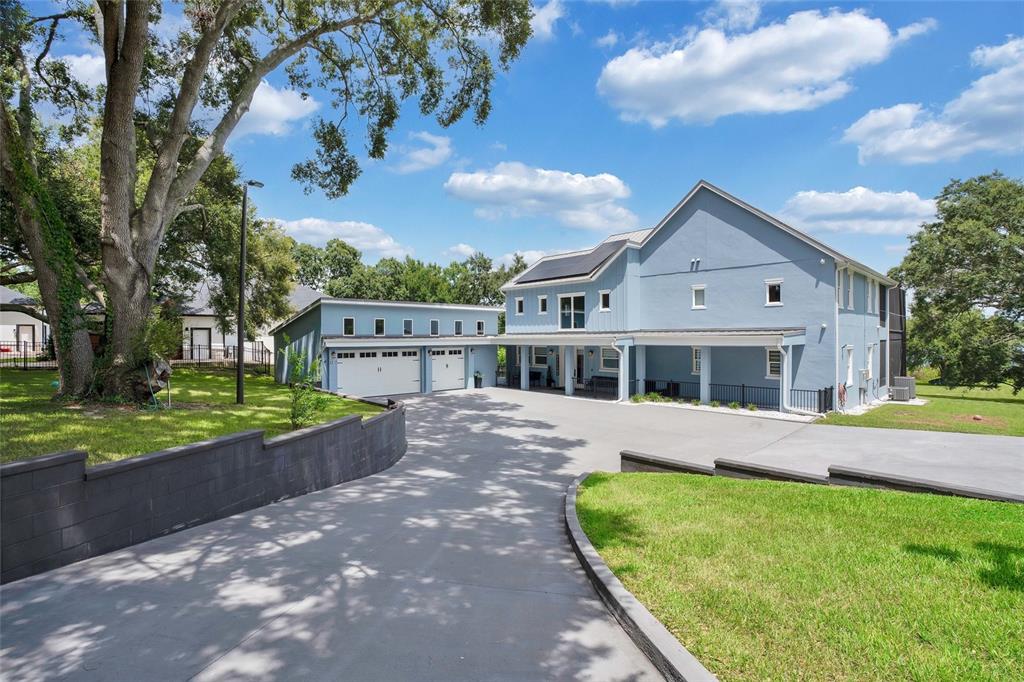 A light blue two-story house with a detached garage and a large concrete driveway — 1317 SPRING LAKE TERRACE, OCOEE, FL