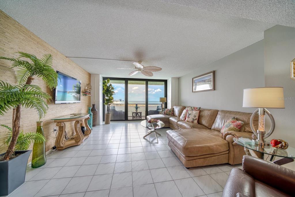 A living room with tile floors, a leather sectional, and a view of the ocean — 450 S GULFVIEW BOULEVARD UNIT 907, CLEARWATER, FL