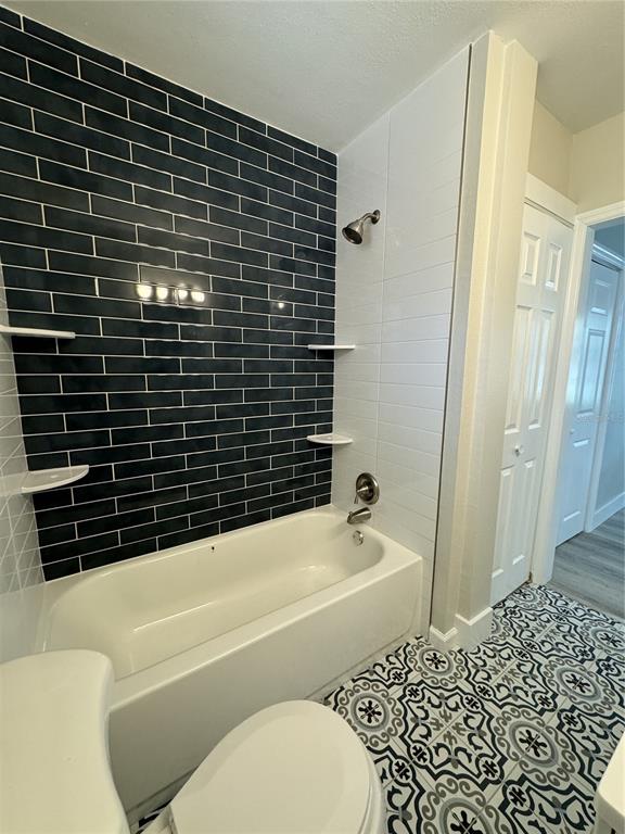 A bedroom with gray wood-look flooring, a ceiling fan, and a sliding barn door entry — 260 20TH AVENUE S, ST PETERSBURG, FL