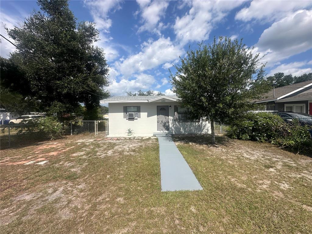 A single-story house with a gray front door and a paved walkway in the yard — 640 N 8TH STREET, EAGLE LAKE, FL