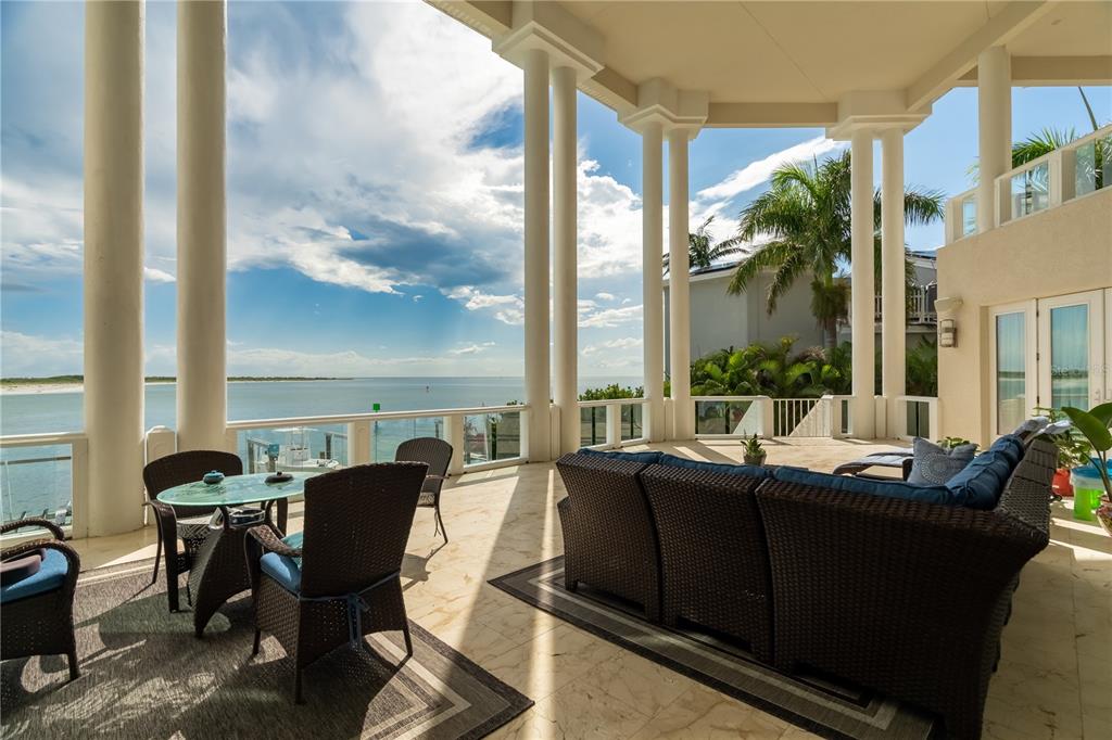 An aerial view of a large white waterfront mansion with a blue metal roof — 774 NINA DRIVE, TIERRA VERDE, FL