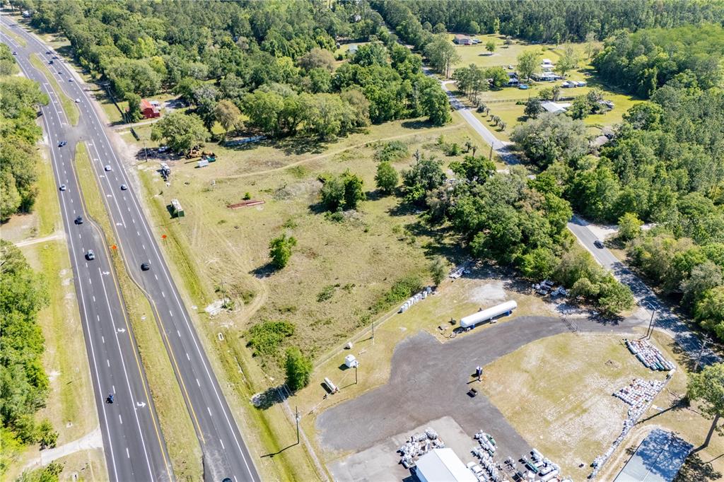 An aerial view shows a highway running alongside a large, partially cleared commercial lot — 9627 US HIGHWAY 301 HIGHWAY N, HAMPTON, FL