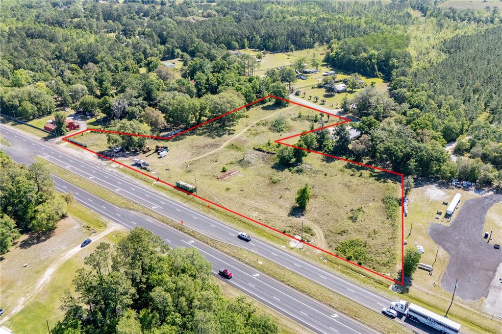 An aerial view shows a vacant, irregularly shaped lot outlined in red next to a highway — 9627 US HIGHWAY 301 HIGHWAY N, HAMPTON, FL
