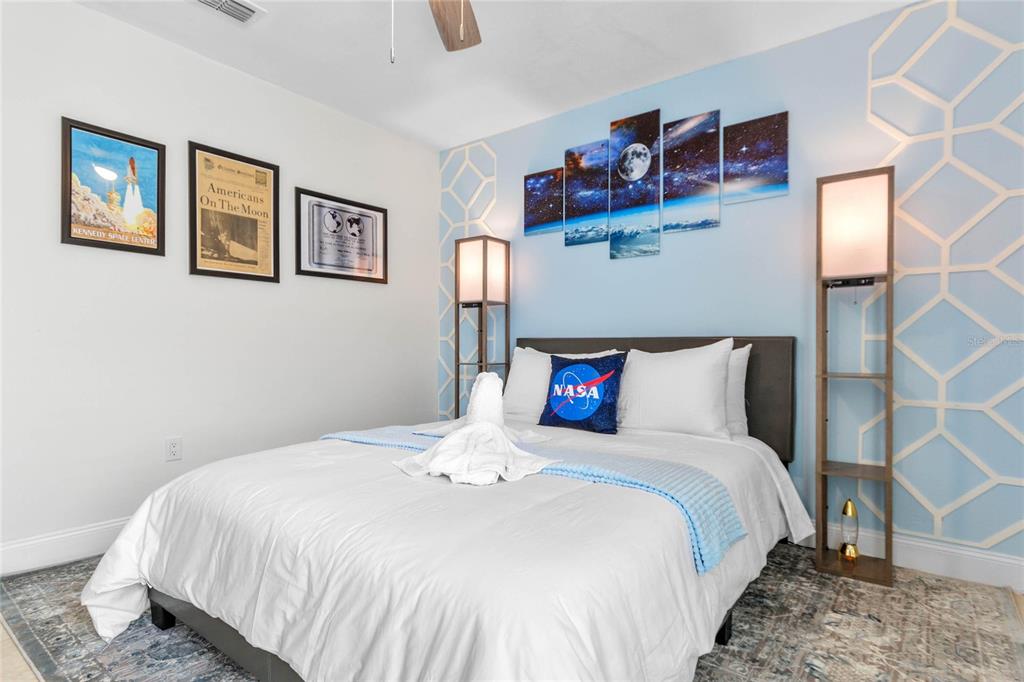 A bedroom features a space-themed decor with NASA artwork, a moon mural, and two floor lamps — 125 HIDDEN SPRINGS CIRCLE, KISSIMMEE, FL