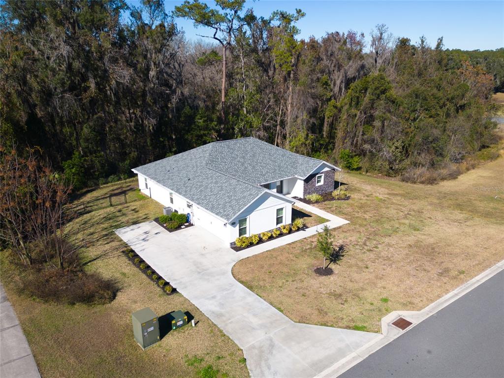 An aerial view of a white single-story house with a gray roof and concrete driveway — 10160 SE 41ST AVENUE, BELLEVIEW, FL