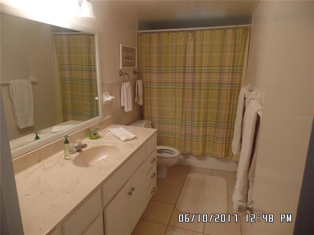 A bathroom features a vanity with a sink, a toilet, and a shower with a curtain — 815 OCEAN SHORE BOULEVARD UNIT 11, ORMOND BEACH, FL