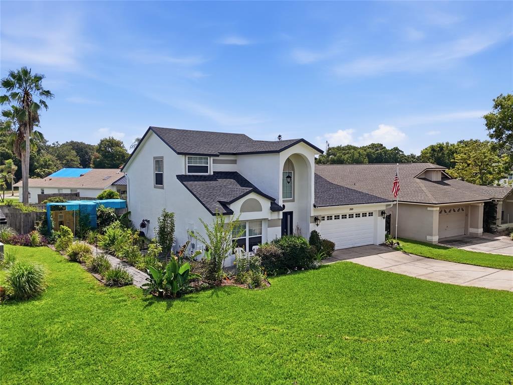 A two-story suburban house with a white garage, arched entryway, and a front lawn — 2909 SOMERSWORTH COURT, ORLANDO, FL