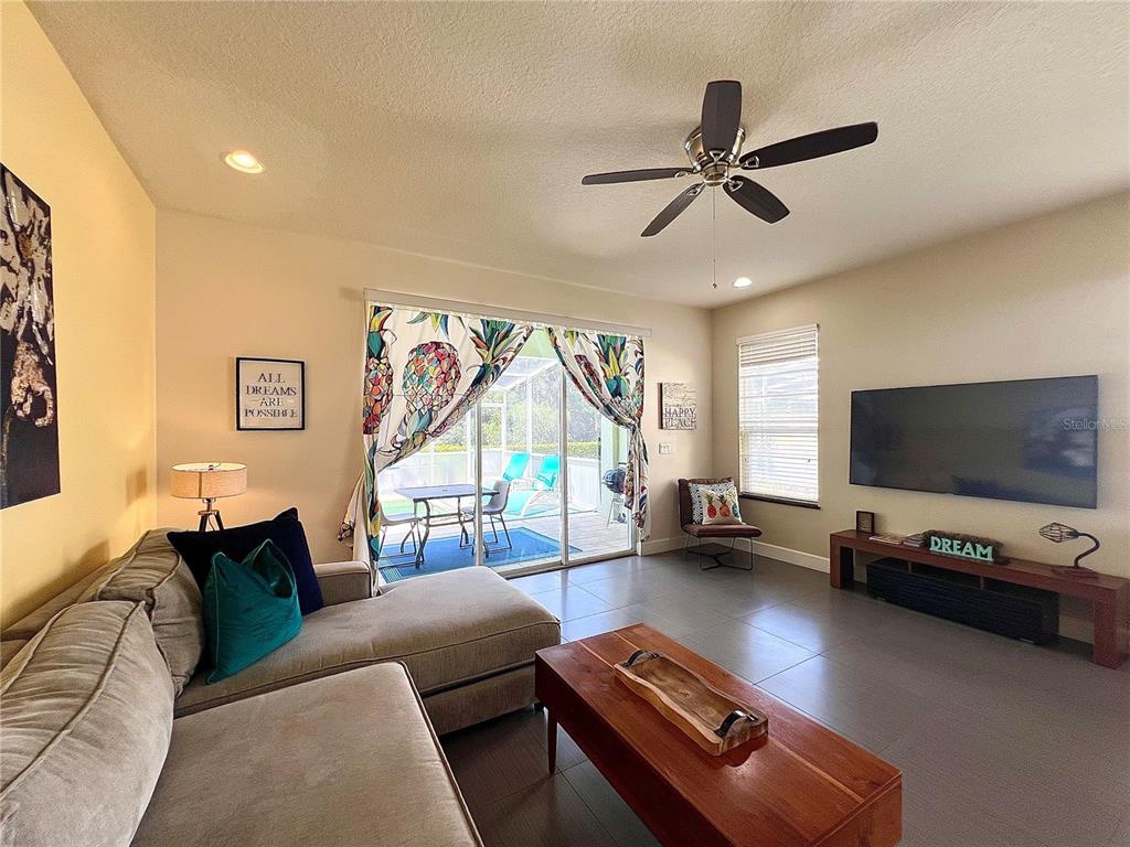 A living room features a sectional sofa, a wooden coffee table, and a sliding glass door — 17407 PLACIDITY AVENUE, CLERMONT, FL