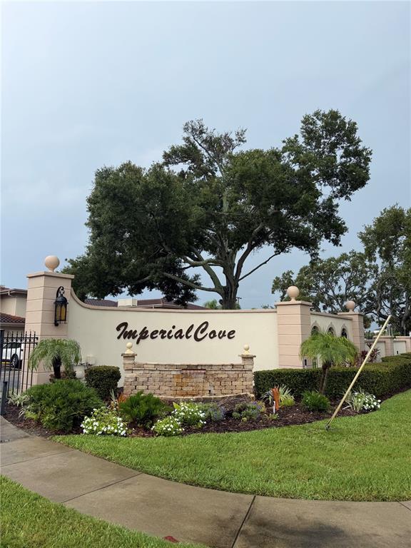 A view of a lake surrounded by apartment buildings, palm trees, and a grassy lawn — 19029 US HIGHWAY 19 N UNIT 2-22, CLEARWATER, FL