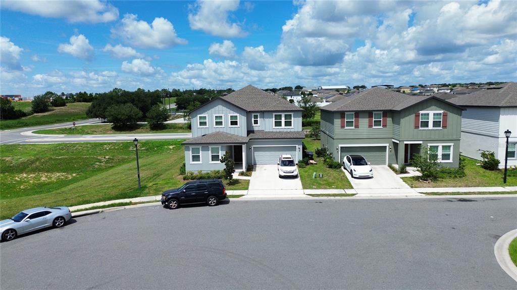 An aerial view shows two suburban houses with driveways and parked cars on a street — 2018 DERWENT DRIVE, DAVENPORT, FL