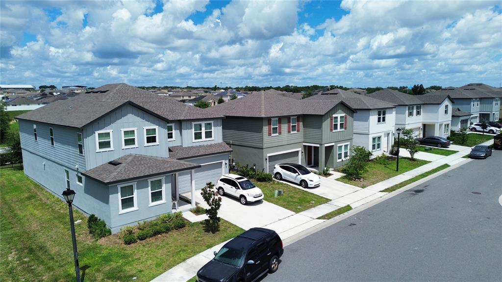 An aerial view shows a row of modern suburban houses with driveways and parked cars — 2018 DERWENT DRIVE, DAVENPORT, FL