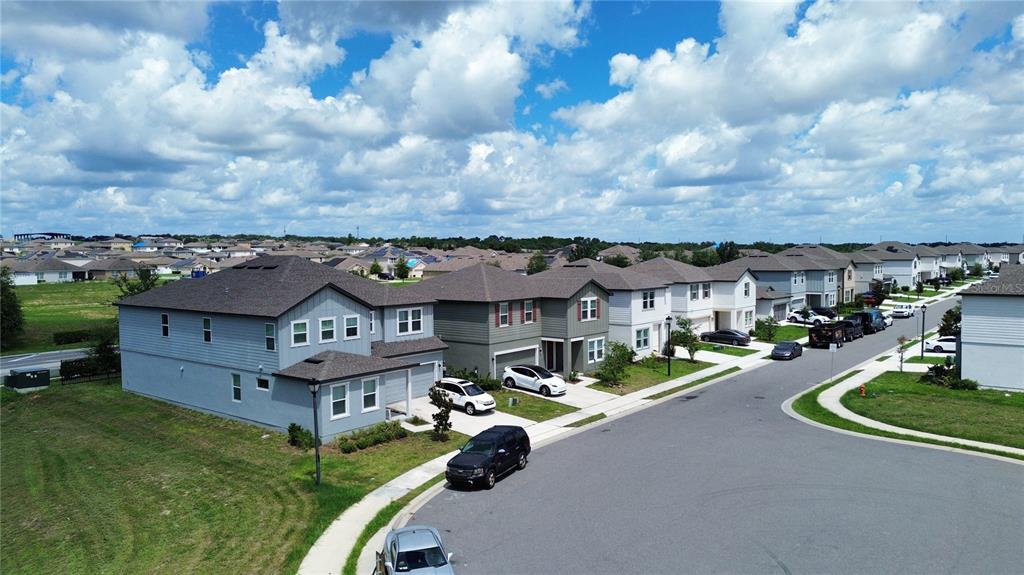 An aerial view shows a suburban street with modern two-story houses and parked cars — 2018 DERWENT DRIVE, DAVENPORT, FL