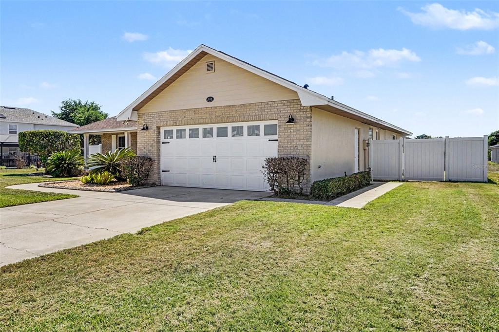 A living room with vaulted ceilings, wood flooring, and a white sectional sofa — 113 SHADDOCK DRIVE, AUBURNDALE, FL