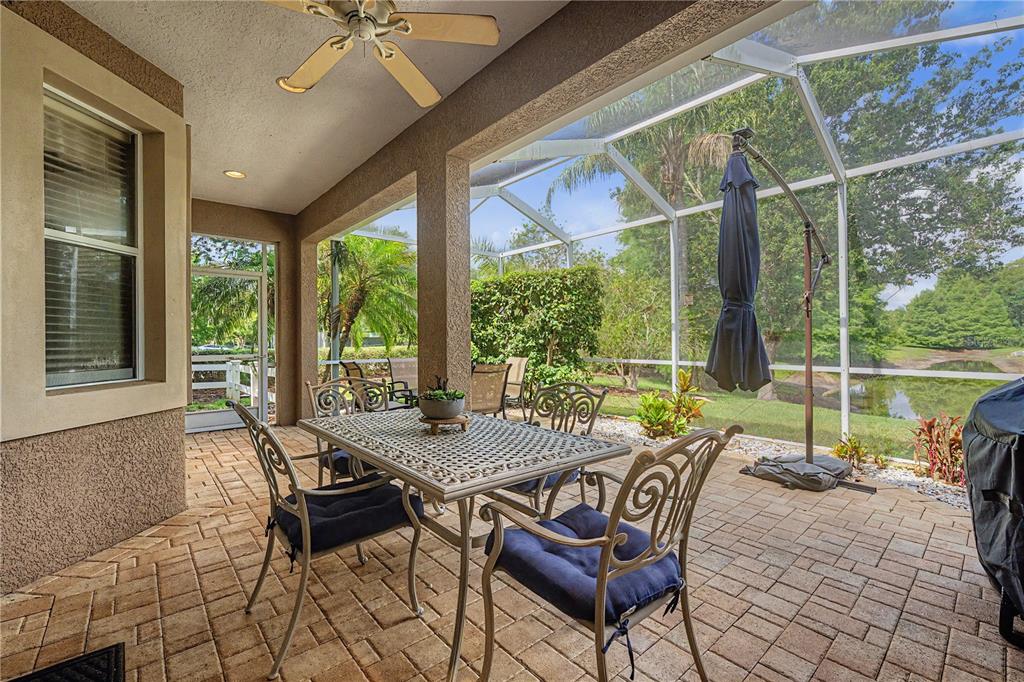 A living room features a beige loveseat, two end tables with lamps, and a large window — 8711 PRESTON WOODS COURT, LAND O LAKES, FL