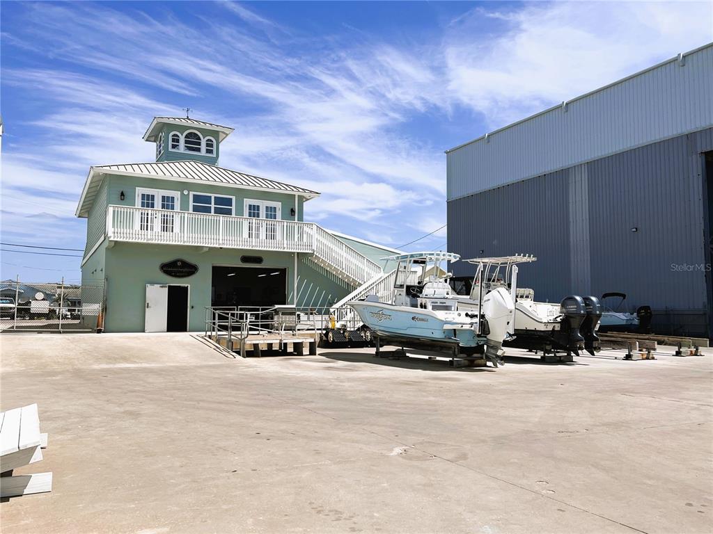 A light green two-story building with a cupola stands next to boats on a lot — 100 CIRCUIT ROAD UNIT S15, NOKOMIS, FL