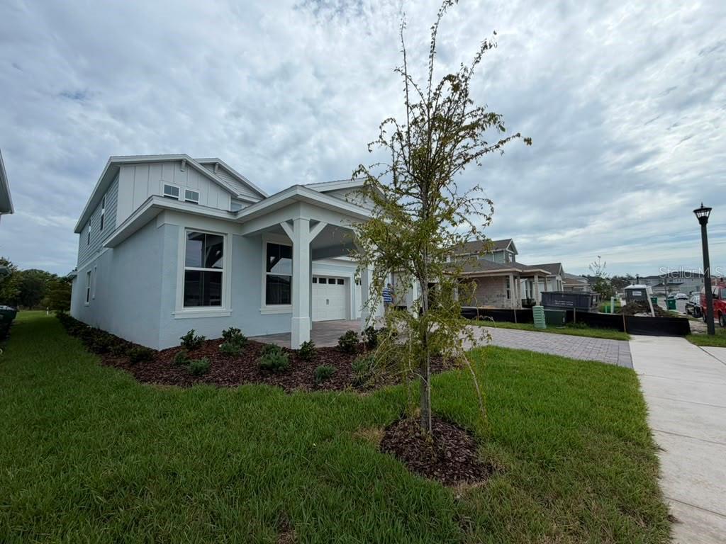 A light-colored single-family home with a covered entryway and a paved driveway — 467 WINTER GROVE BOULEVARD, WINTER GARDEN, FL