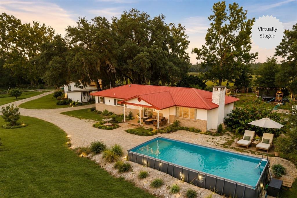 An aerial view of a house with a red metal roof and an above-ground pool — 1750 SW 17TH TERRACE, BELL, FL