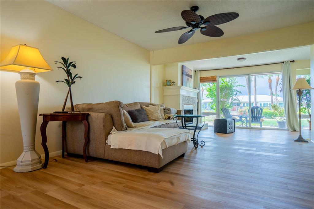 A living room features a sectional sofa, a fireplace, and sliding glass doors to a patio — 3289 FAIRHAVEN LANE UNIT 112, SARASOTA, FL