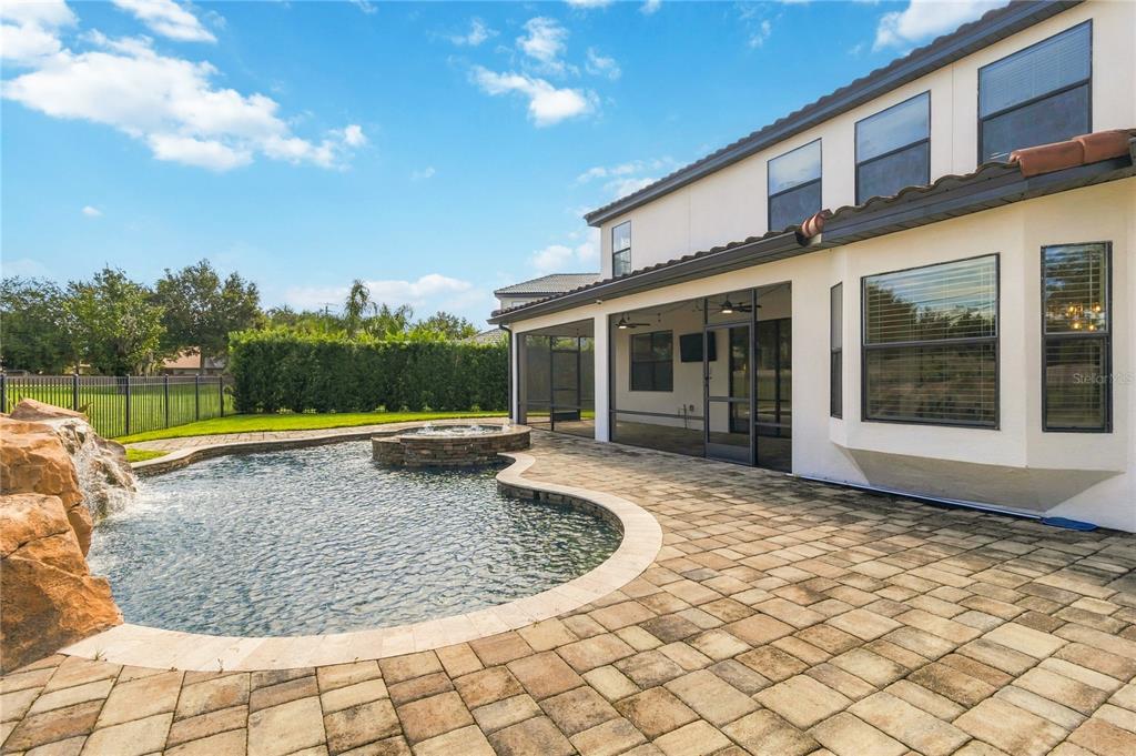 A two-story house with a screened patio, a pool with a fountain, and rock features — 5785 SAYBROOK CIRCLE, SANFORD, FL