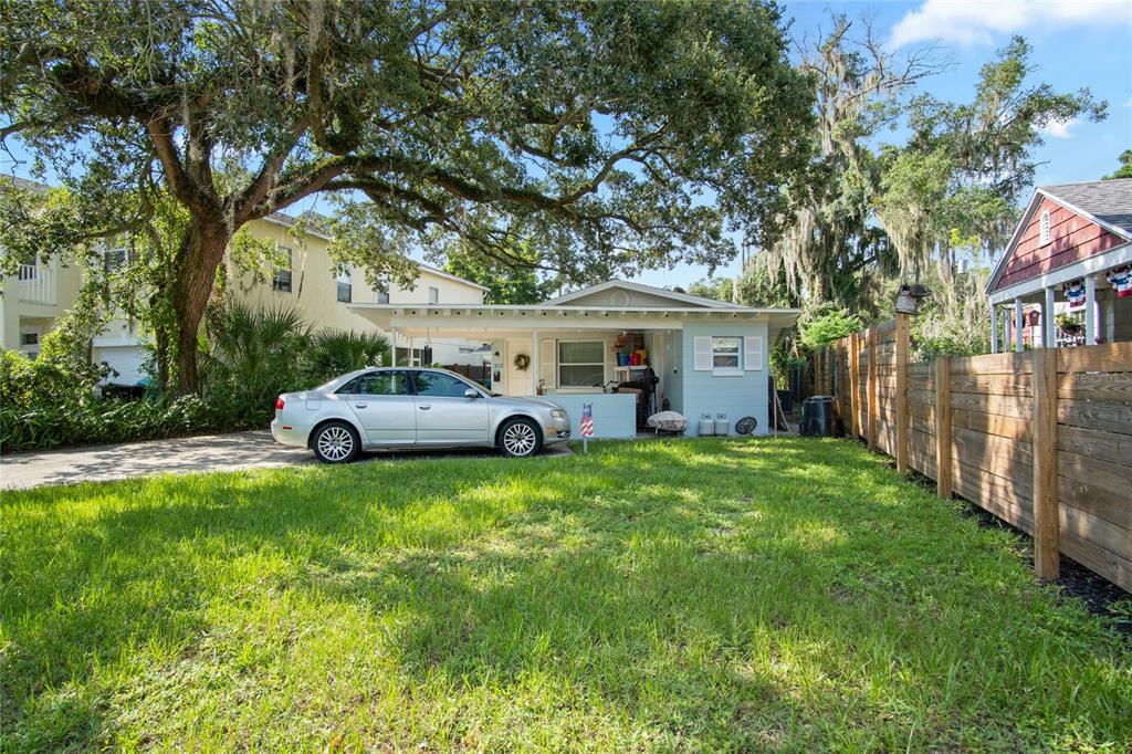A light blue house with a covered front porch sits behind a grassy front yard — 212 E HARVARD STREET, ORLANDO, FL
