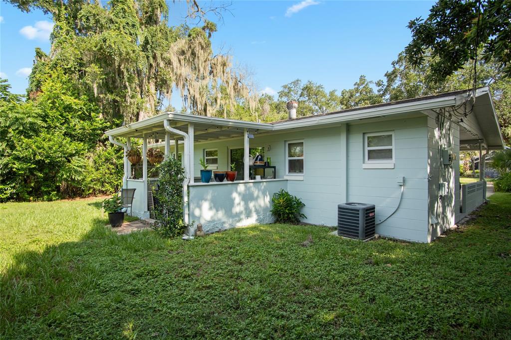 The exterior of a light green house features a screened-in porch and a backyard lawn — 212 E HARVARD STREET, ORLANDO, FL