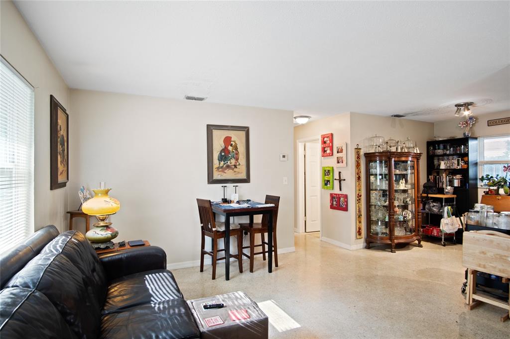 A living room features a black leather sofa, a small dining table, and a curio cabinet — 212 E HARVARD STREET, ORLANDO, FL