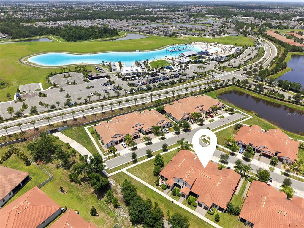 Aerial view of a residential neighborhood featuring a large lagoon and community clubhouse — 5305 STOIC VALE DRIVE, WIMAUMA, FL