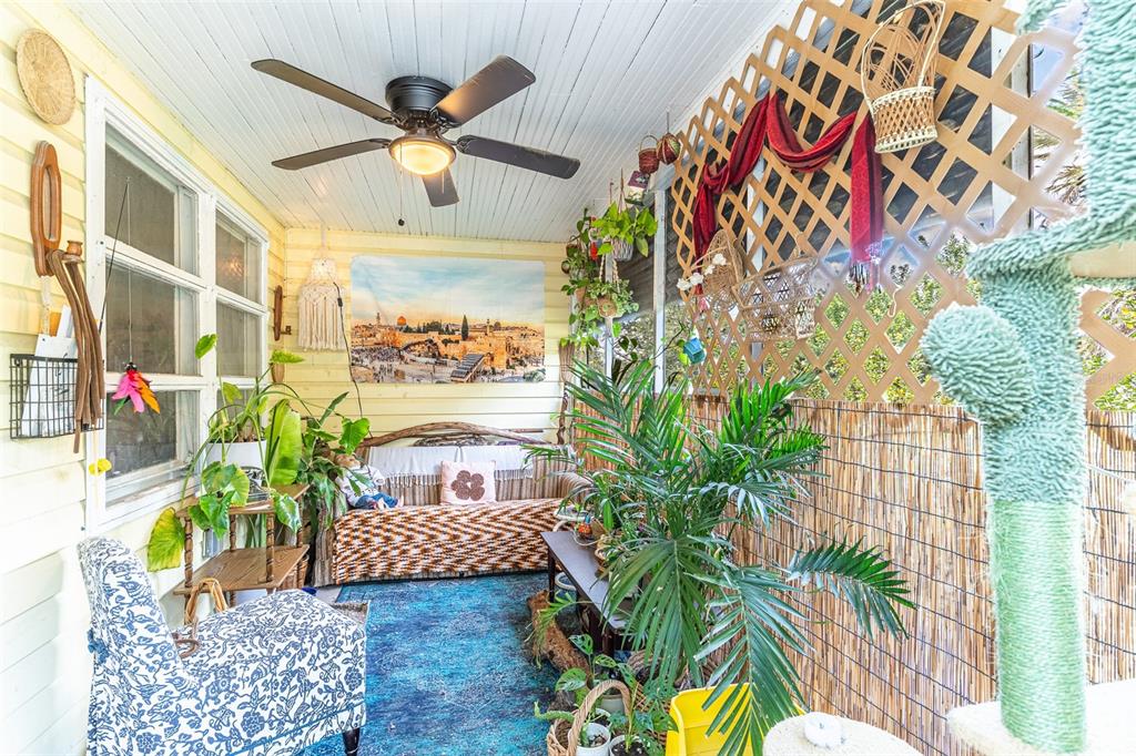 A sunroom features a ceiling fan, a patterned rug, potted plants, and a couch — 1120 S SCENIC HIGHWAY, LAKE WALES, FL