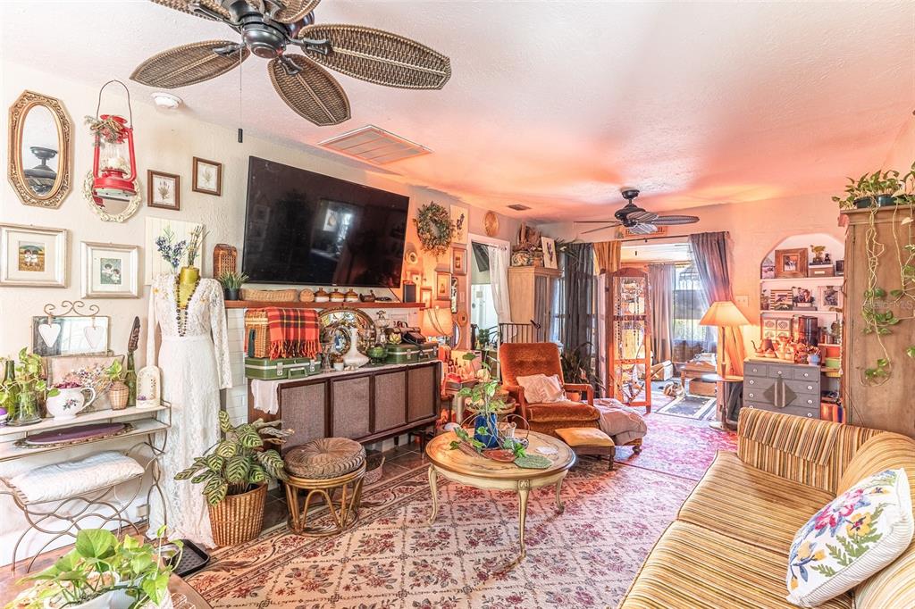A living room features a patterned rug, a striped sofa, and a television above furniture — 1120 S SCENIC HIGHWAY, LAKE WALES, FL