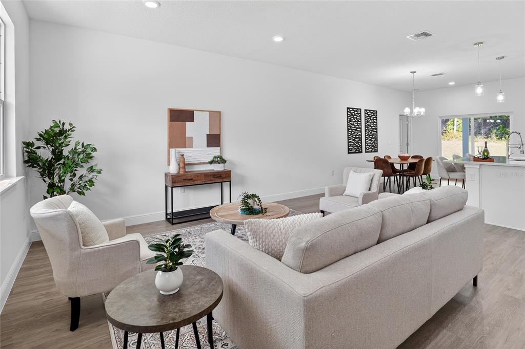 A dining room features a wooden table, six brown chairs, wall art, and a sliding door — 99 W GOLDCOAST PLACE, DUNNELLON, FL