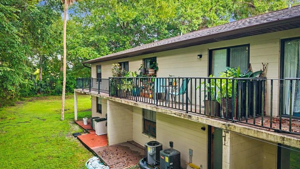 An aerial view shows two apartment buildings with a shared parking lot and surrounding trees — 1679 SPRING GARDEN COURT, HOLLY HILL, FL