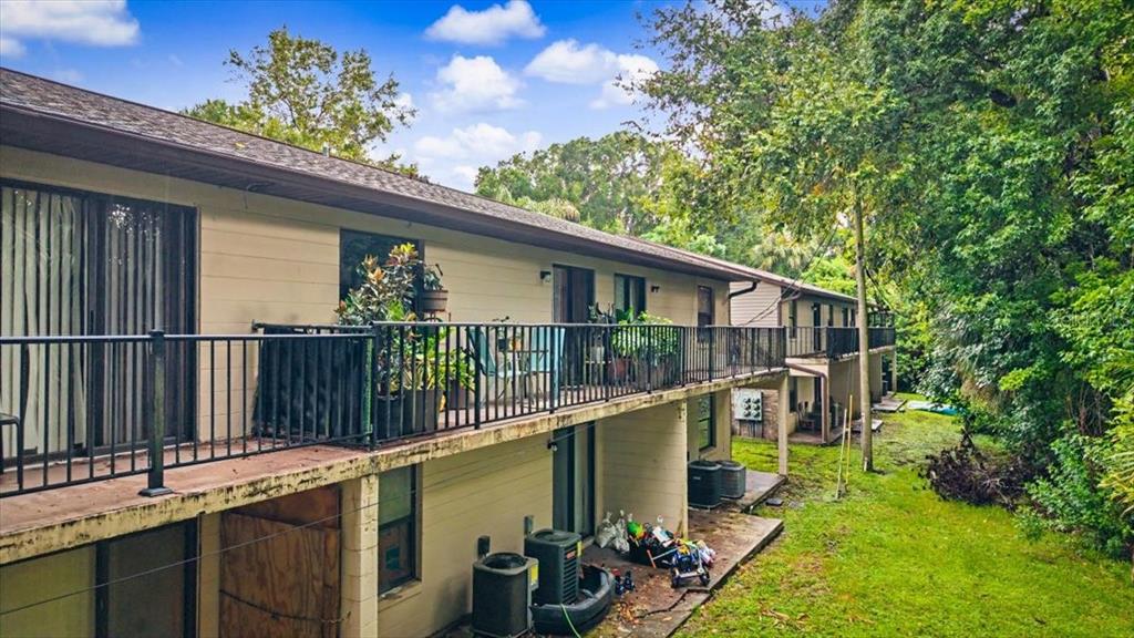 An exterior view of a two-story apartment building with orange doors and metal staircases — 1679 SPRING GARDEN COURT, HOLLY HILL, FL