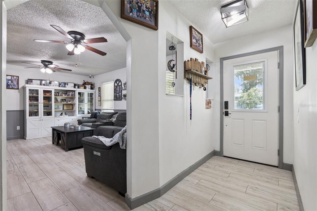 A single-story house with a light-colored exterior, a shingled roof, and an attached garage — 1629 ORANGE TREE DRIVE, EDGEWATER, FL