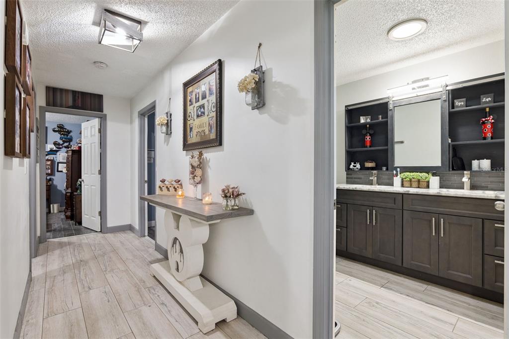 A view from an entryway into a living room with gray tile floors and ceiling fans — 1629 ORANGE TREE DRIVE, EDGEWATER, FL