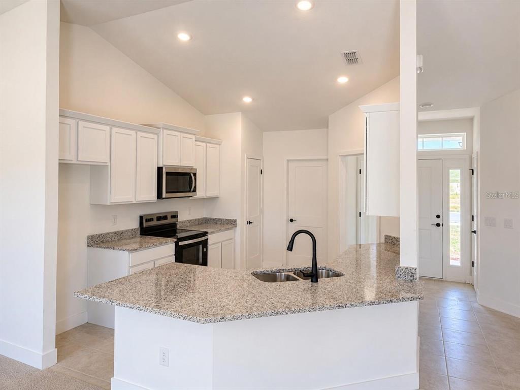 A bedroom features a white double-door closet with wire shelving and a closed door nearby — 1684 ANN ROSE WAY, LEESBURG, FL