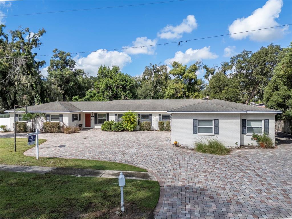 This aerial view shows a house with a paver driveway on a large corner lot — 712 S OAKWOOD AVENUE, BRANDON, FL