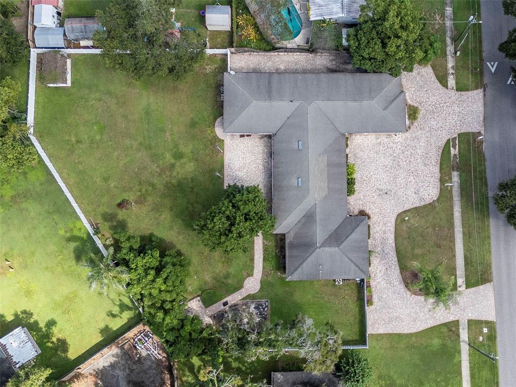 A brick house exterior features a red front door, a paver patio, and rocking chairs — 712 S OAKWOOD AVENUE, BRANDON, FL
