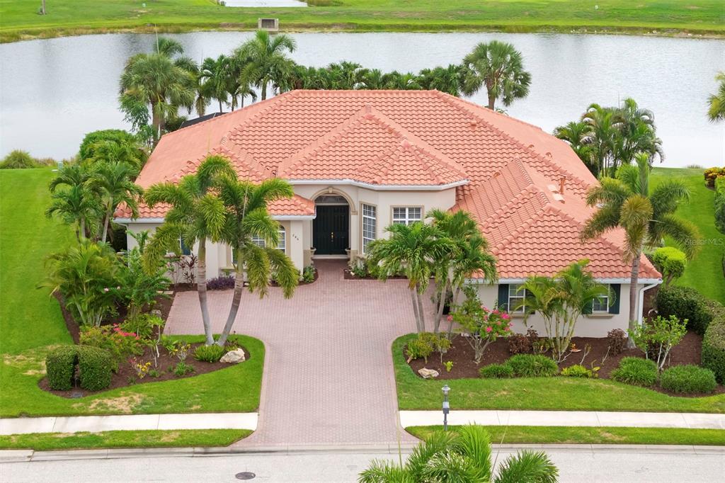 An aerial view of a single-story house with a tile roof and a paved driveway — 286 PESARO DRIVE, NOKOMIS, FL