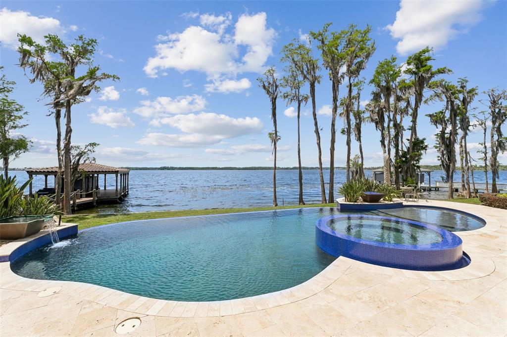 A large Mediterranean-style house features a stone driveway, arched entryway, and a tiled roof — 9236 BAY POINT DRIVE, ORLANDO, FL