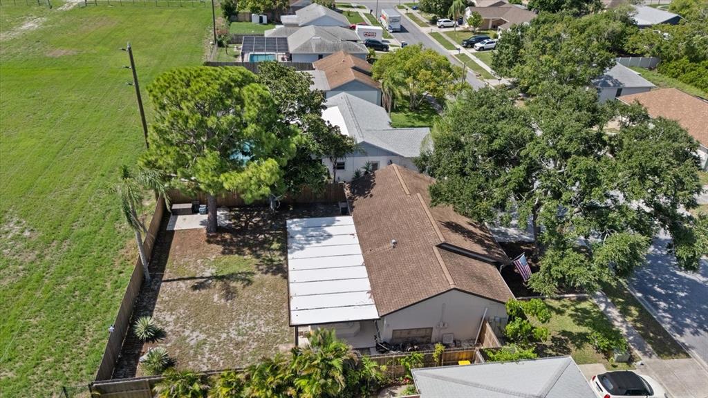 An aerial view shows a house with a brown roof, a white patio cover, and a backyard — 1310 MANDARIN DRIVE, HOLIDAY, FL