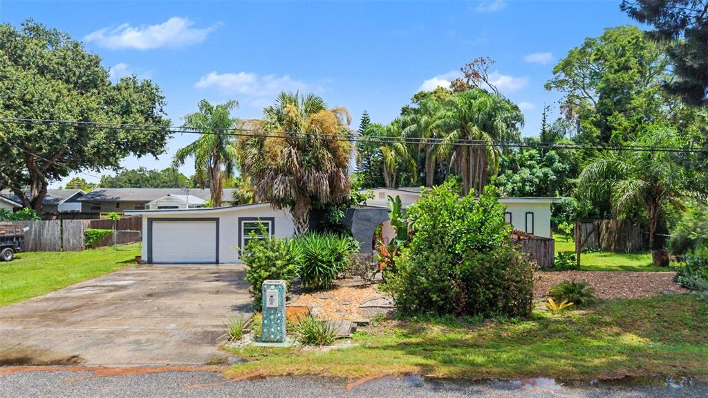 A single-story house with a white exterior, a garage, and a large front yard with trees — 2767 BELLE HAVEN DRIVE, CLEARWATER, FL