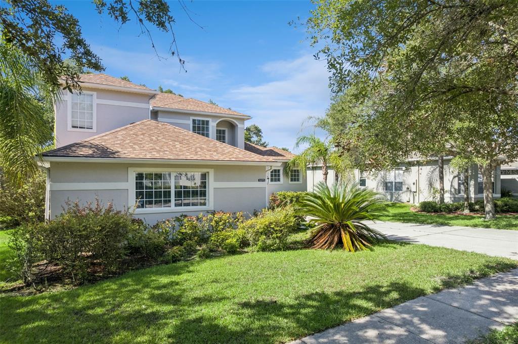 A two-story house with a light-colored exterior, a shingled roof, and a landscaped front yard — 5270 RISHLEY RUN WAY, MOUNT DORA, FL