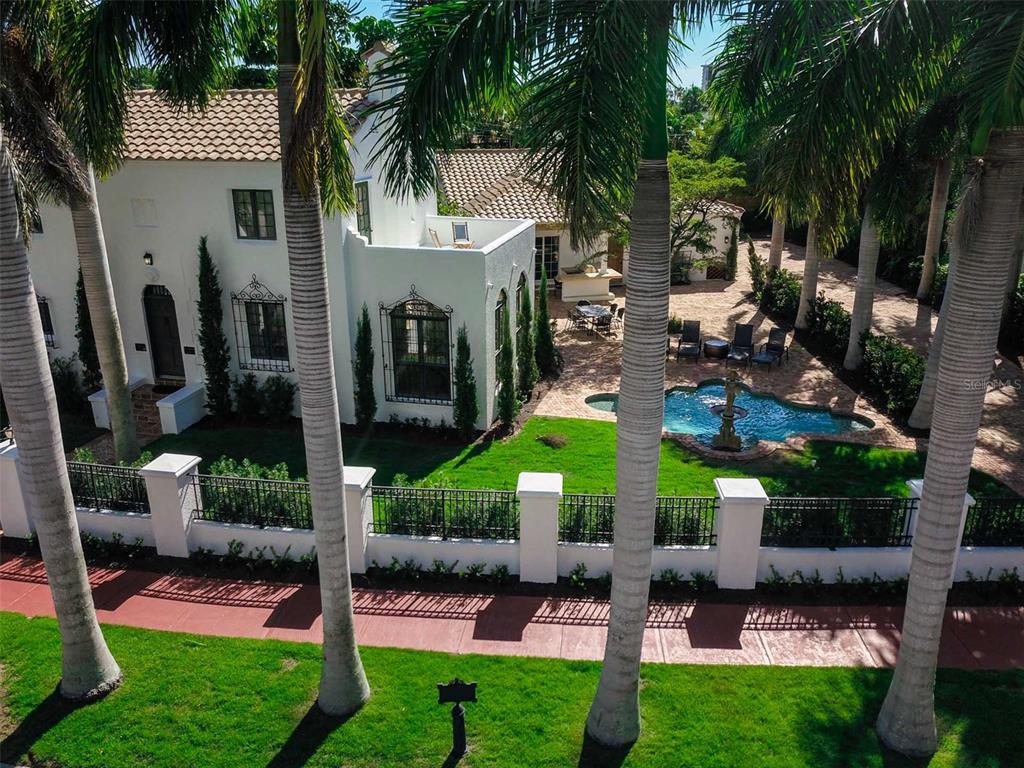 An aerial view of a white stucco house with a tiled roof, pool, and palm trees — 76 S WASHINGTON DRIVE, SARASOTA, FL