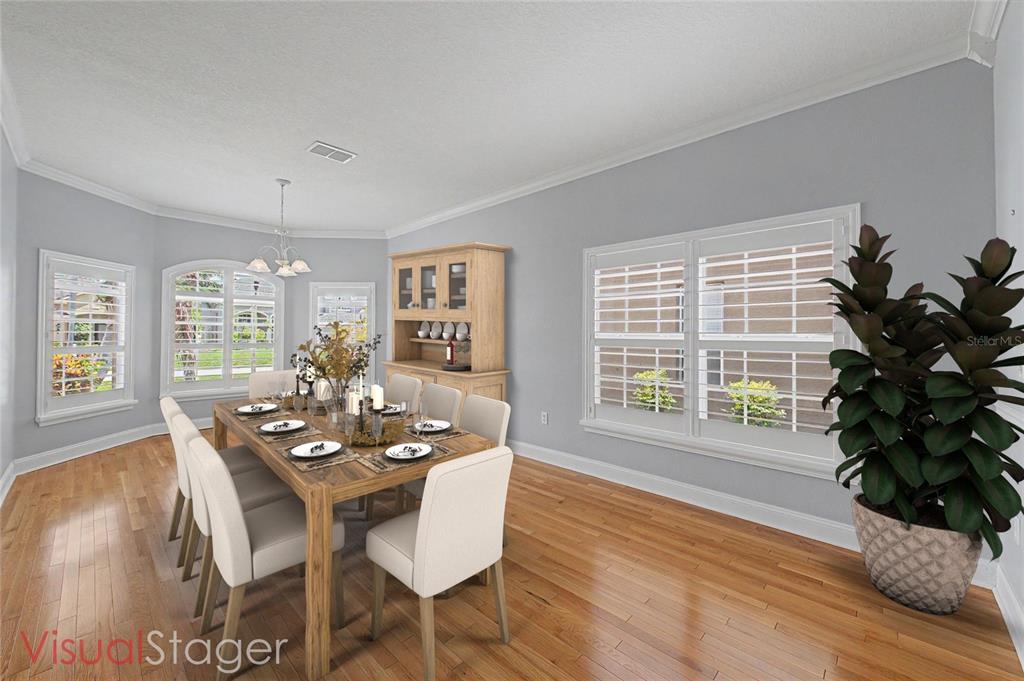 A dining room with hardwood floors, a wooden hutch, and a table with six chairs — 2811 RAVENDALE LANE, HOLIDAY, FL