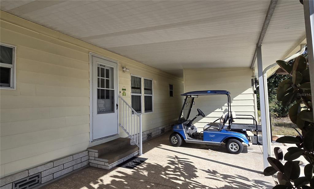 A single-story mobile home with light siding, metal window awnings, and an attached carport — 3450 N CITRUS CIRCLE UNIT GE, ZELLWOOD, FL