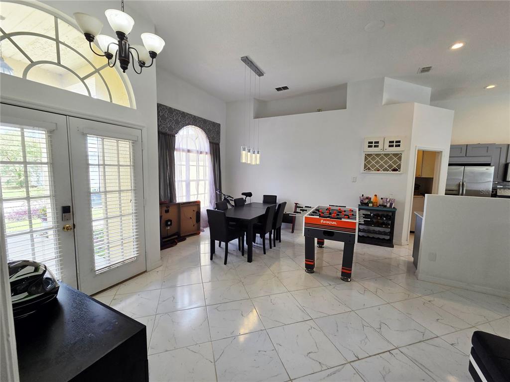 A covered patio features a red pool table, a swimming pool, and a screened enclosure — 10 NEVADA LOOP ROAD, DAVENPORT, FL