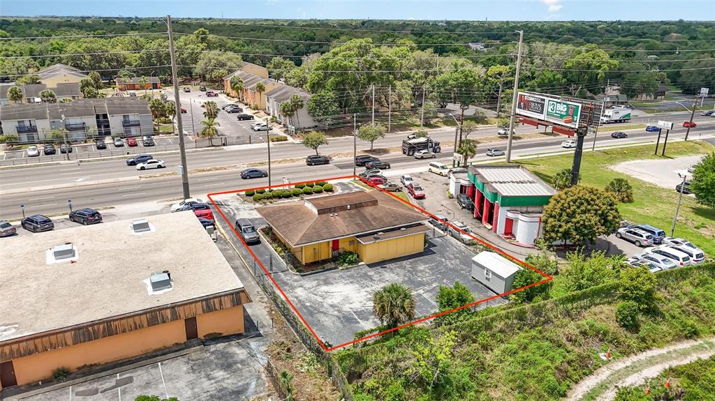 An aerial view shows a yellow commercial building with a parking lot outlined in red — 6005 SILVER STAR ROAD, ORLANDO, FL