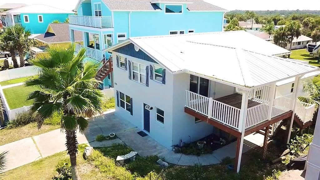 An elevated two-story house with a white metal roof and a large wooden deck — 1828 S CENTRAL AVENUE, FLAGLER BEACH, FL